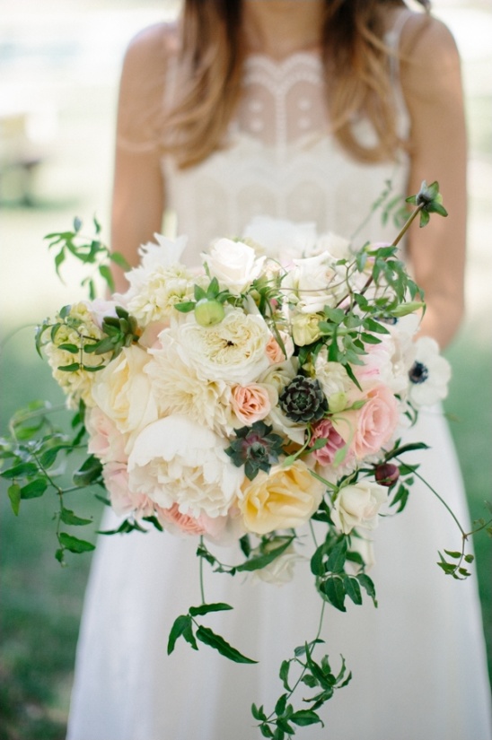 Bride holding a lush romantic bouquet of pastel flowers