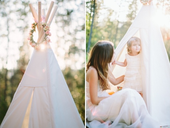 Mother and daughter playing in a decorated teepee outside