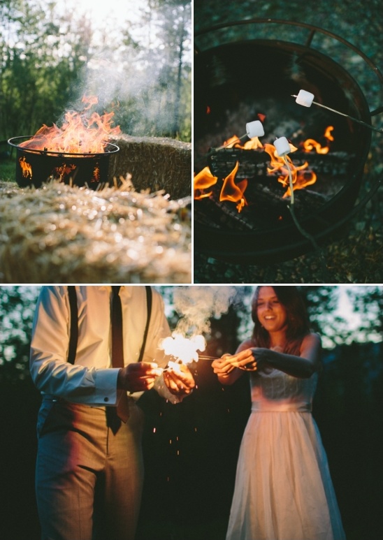 Romantic couple roasting marshmallows and sparking fireworks by bonfire