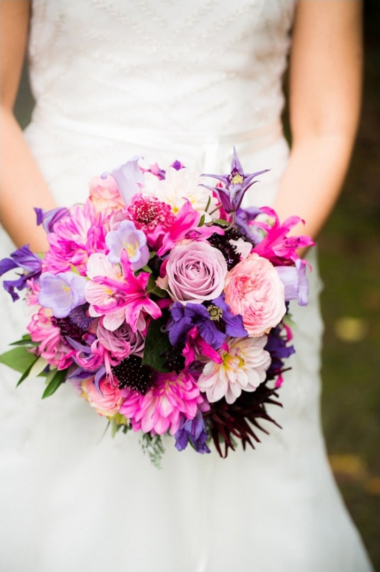 Bride holding a vibrant bouquet of pink and purple wedding flowers
