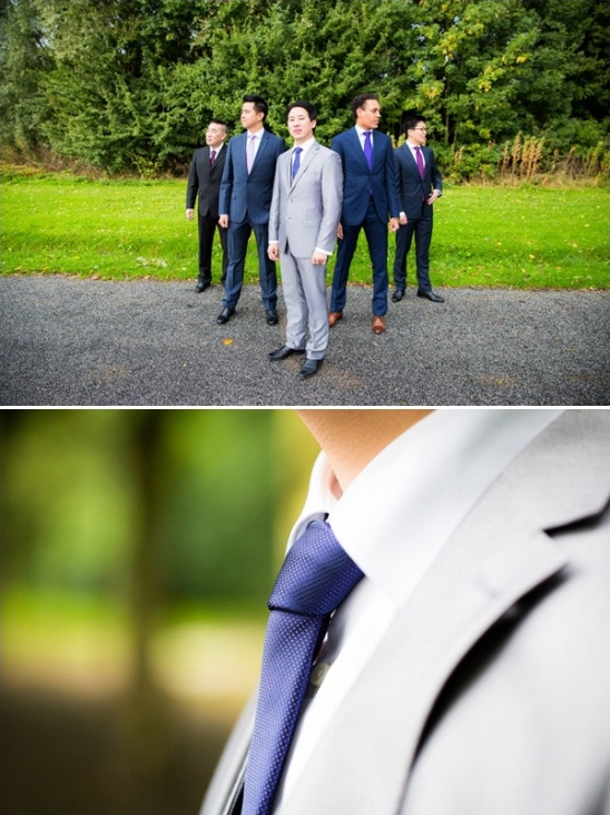 A group of well dressed men in suits pose for a photo outdoors