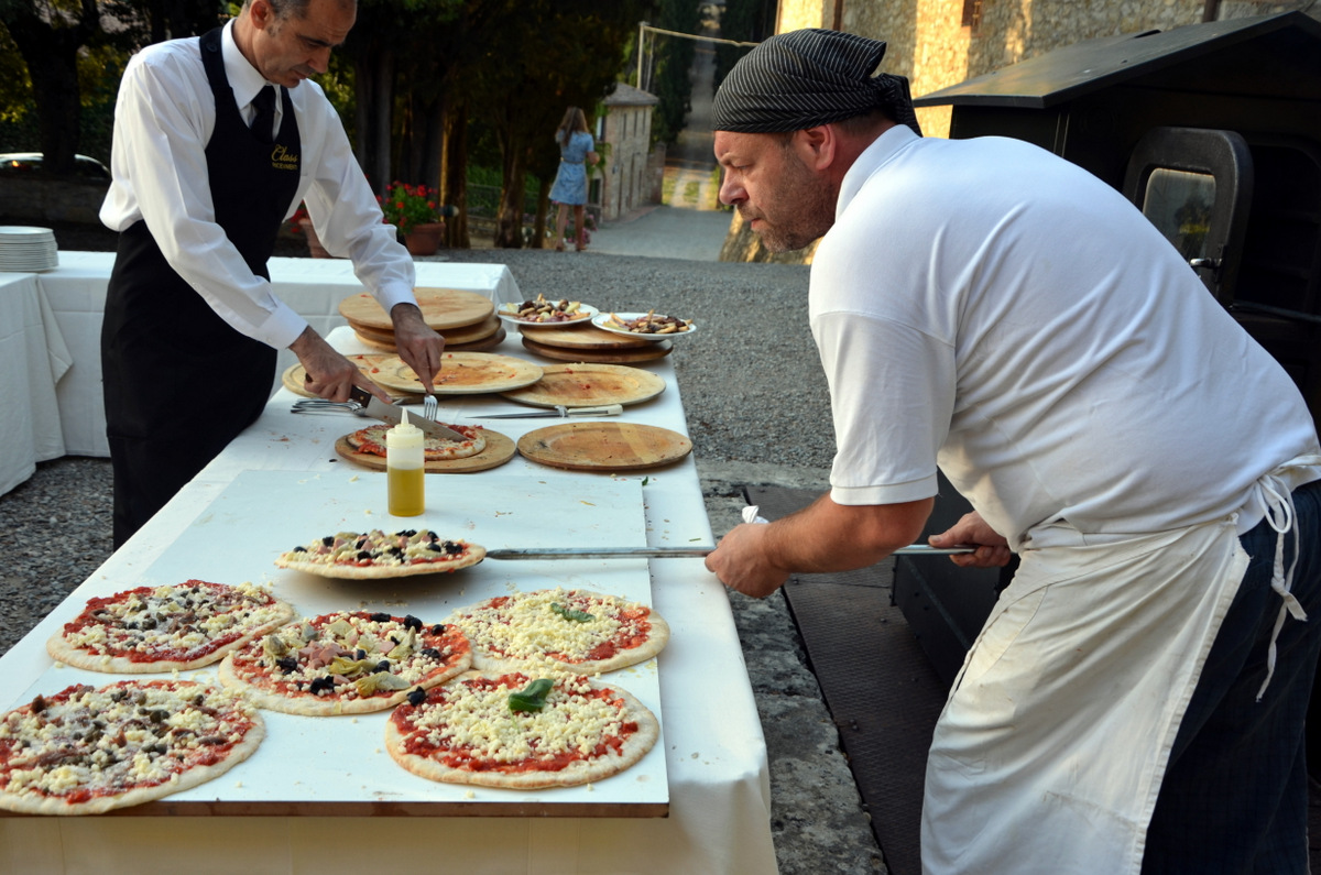 Chefs preparing and serving fresh, delicious pizzas for a gathering