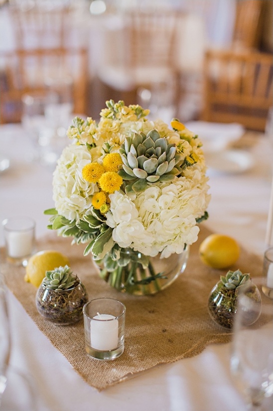 Elegant floral centerpiece with succulents and lemons on table