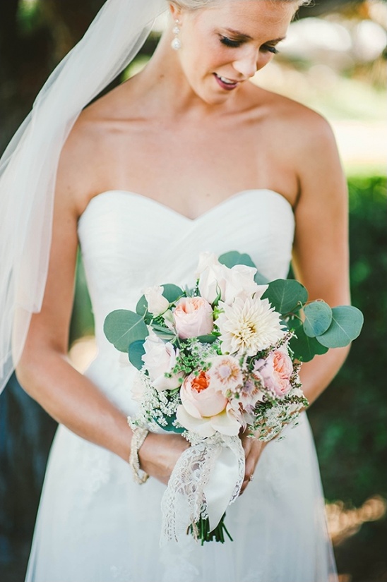 Happy bride holding a floral bouquet in a beautiful wedding dress