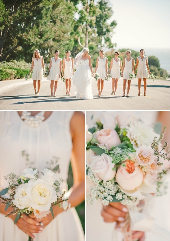 Bride and bridesmaids in white dresses, walking in a road