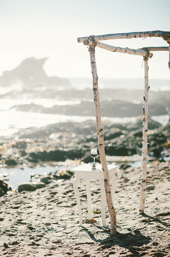 Beach wedding ceremony decor with table and a glass