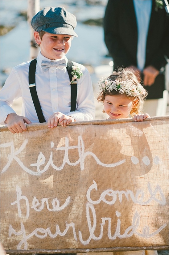 Young children at a wedding carrying a sign, Here comes your bride