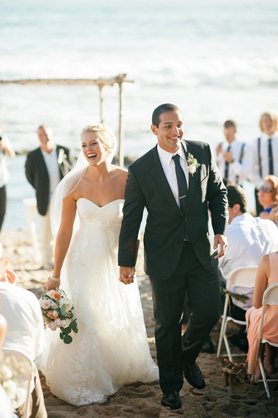 Newlyweds beaming with joy after their beach wedding ceremony