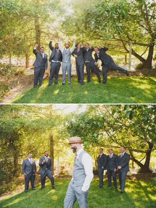 Groomsmen celebrating in a park, dressed in suits and smiling joyfully