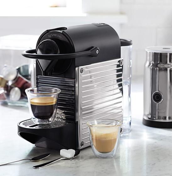 Nespresso coffee machine with two cups of espresso and accessories