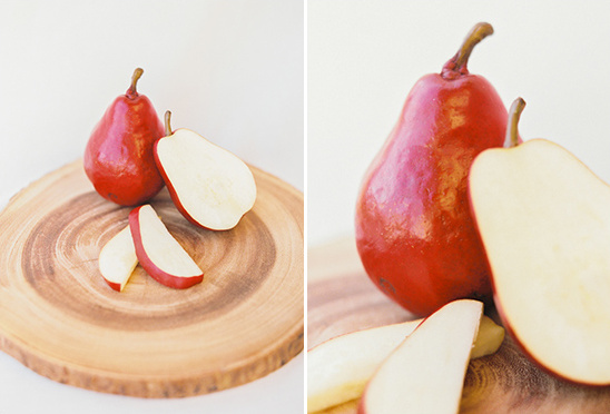 Red pears and slices on wood board