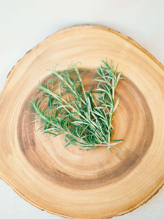 Fresh rosemary sprigs on wooden platter