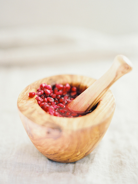 Pomegranate seeds in wooden mortar and pestle