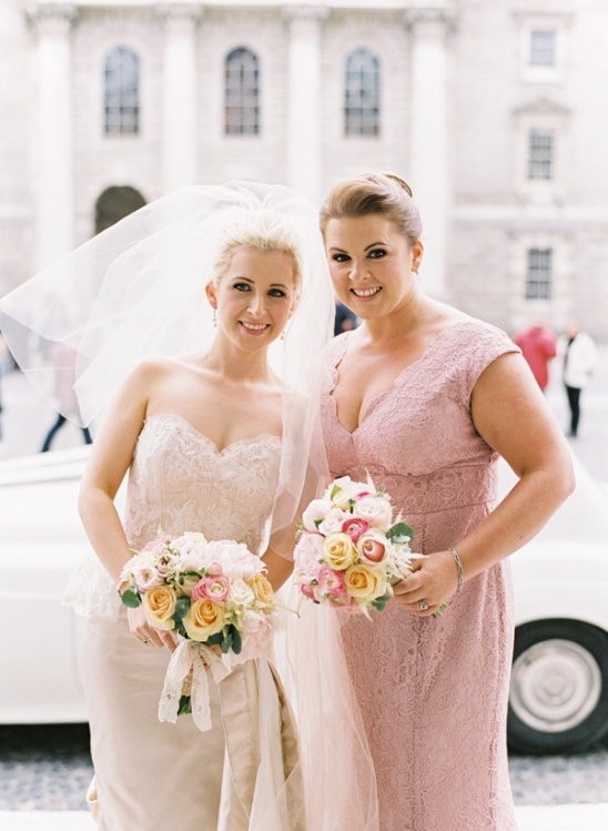 Bride and bridesmaid pose with bouquets