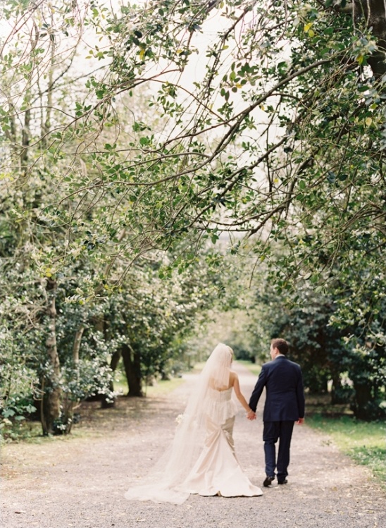 Couple walking hand-in-hand wedding outdoors