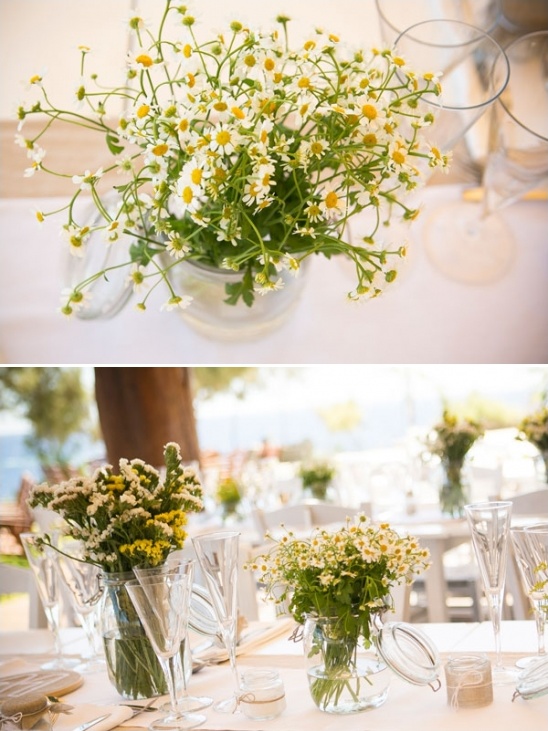 Wedding table decor with chamomile flowers in mason jars