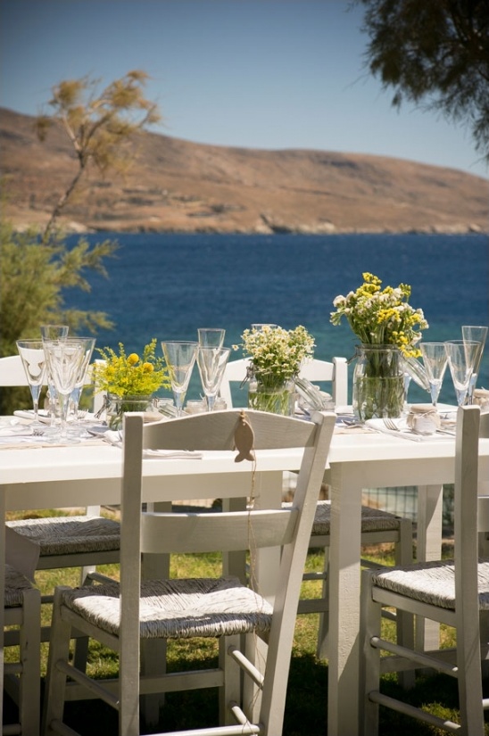Coastal dining table setup with ocean view background