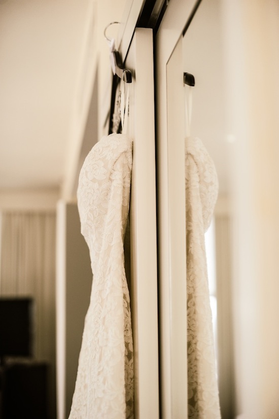 Elegant lace wedding dress hanging in closet