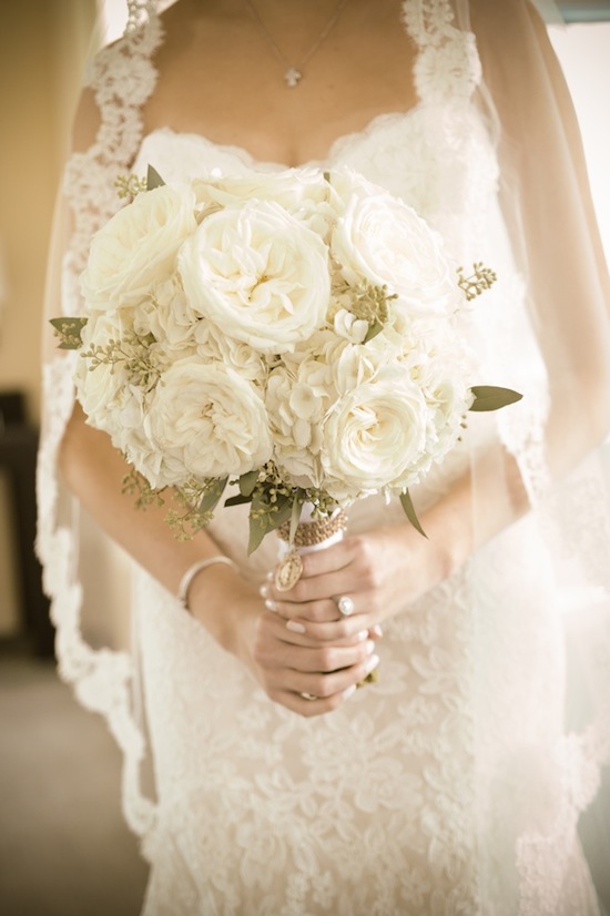 Bride holding elegant white rose wedding bouquet