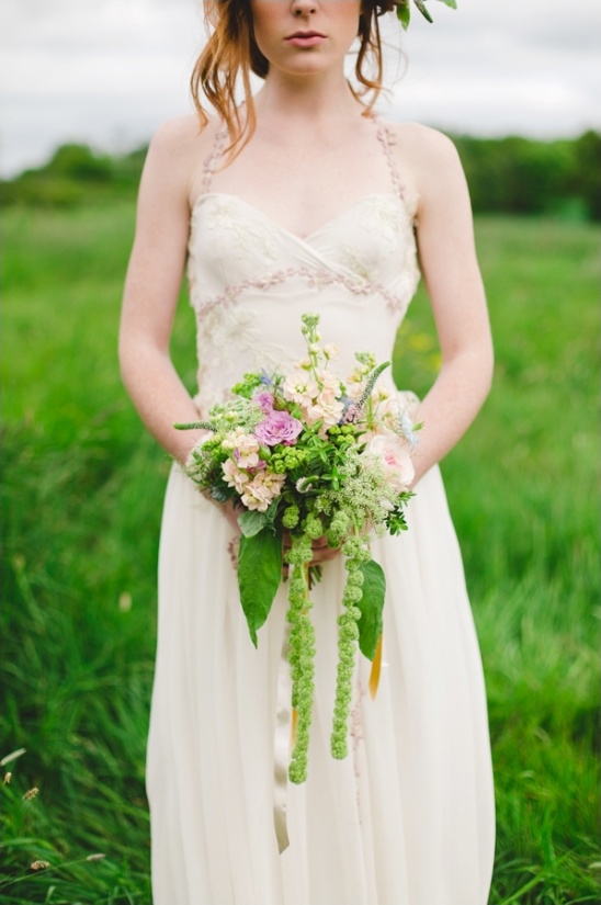 Bride in white dress holding flower bouquet outdoor