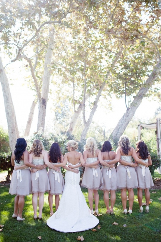 Bride and bridesmaids pose in neutral dresses outdoors