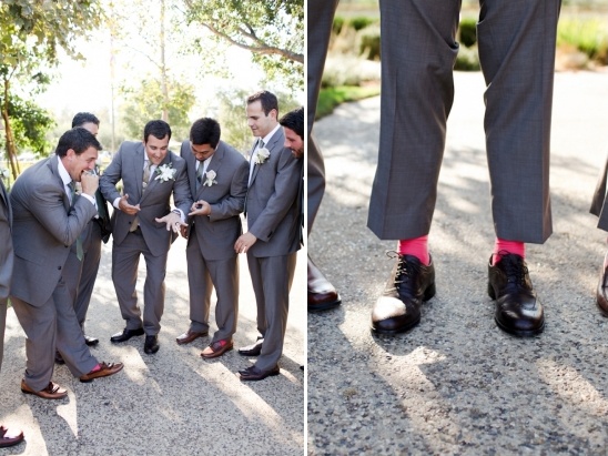 Groomsmen show off fun pink socks with gray suits wedding