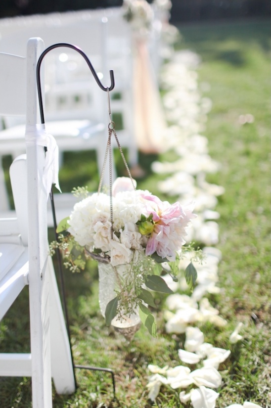 Wedding aisle decor flowers hanging from a chair