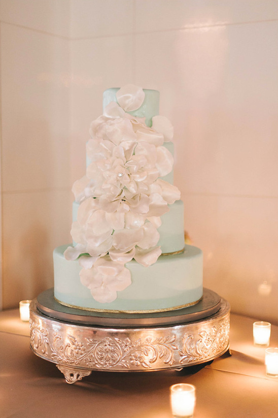 mint and gold wedding cake decorated with white petals