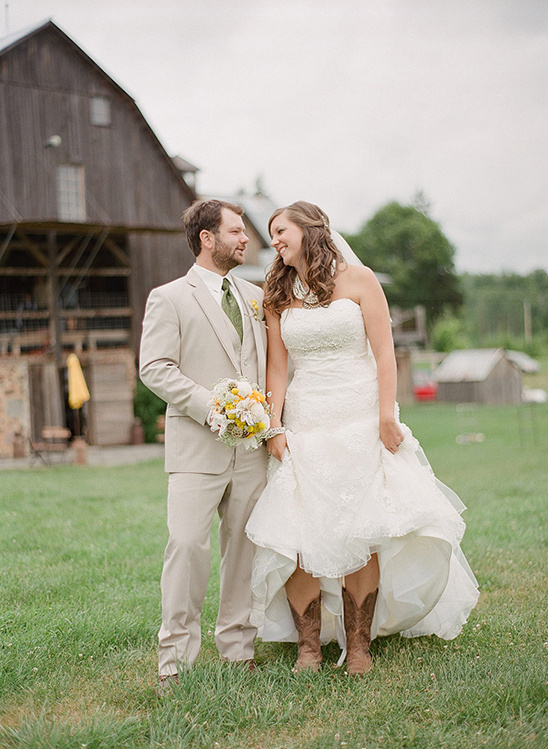 Happy bride and groom smiling at rustic barn wedding