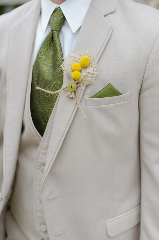 Groom in beige suit with green tie and boutonniere
