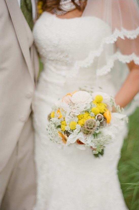 Bride in lace dress with yellow and white wedding bouquet