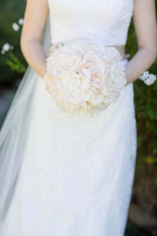 Bride holding a delicate ivory rose wedding bouquet