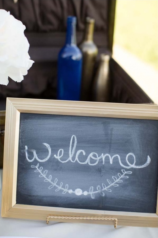 Welcome sign chalkboard with bottles in background