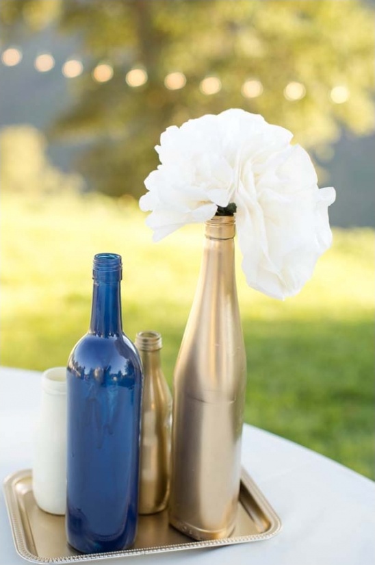 Gold and blue painted bottles with white flower arrangement