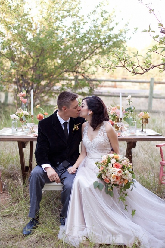 Bride and groom kissing at their outdoor wedding reception