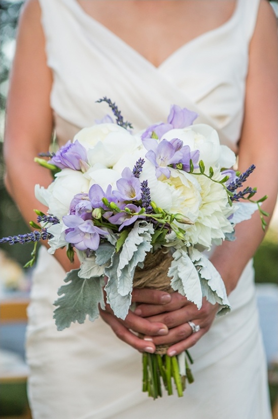 Bride holding elegant white and purple wedding bouquet