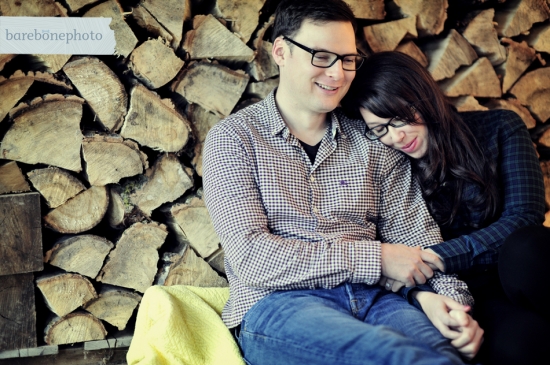 Couple cuddling by fireplace logs