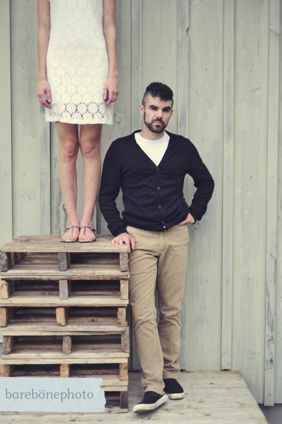 Couple posing on wooden pallets, rustic engagement photo