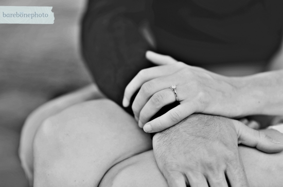 Closeup of hands clasped together, showing an engagement ring