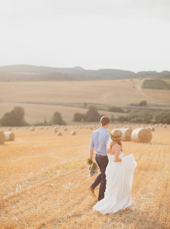 Rustic wedding couple walking in a field