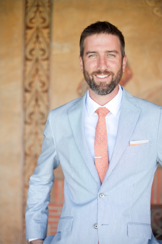 groom in pinstried suit and coral tie