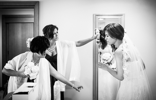 Bride getting hair sprayed before her wedding day
