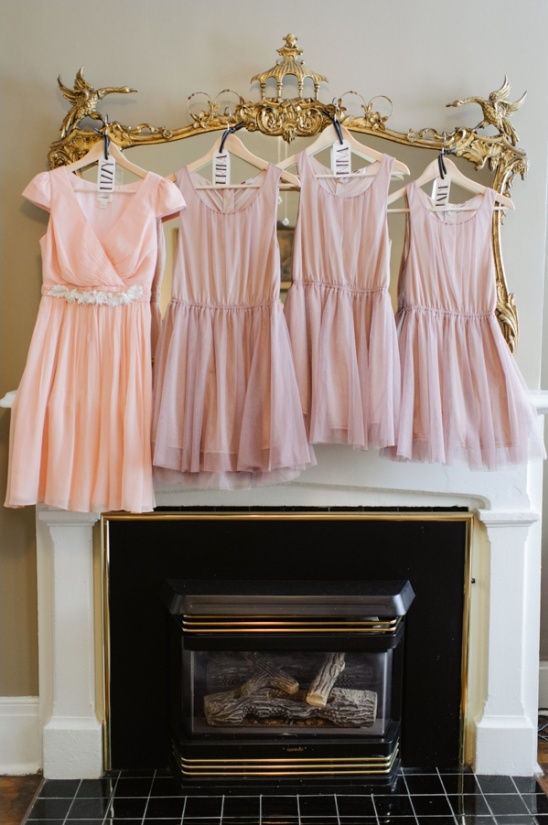 Pink bridesmaid dresses hanging over fireplace