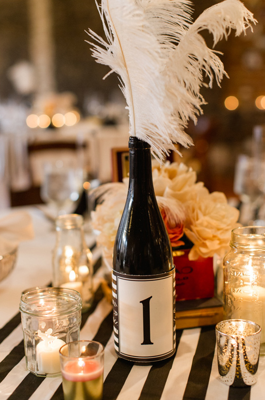 Table setting with white feathers and number one bottle
