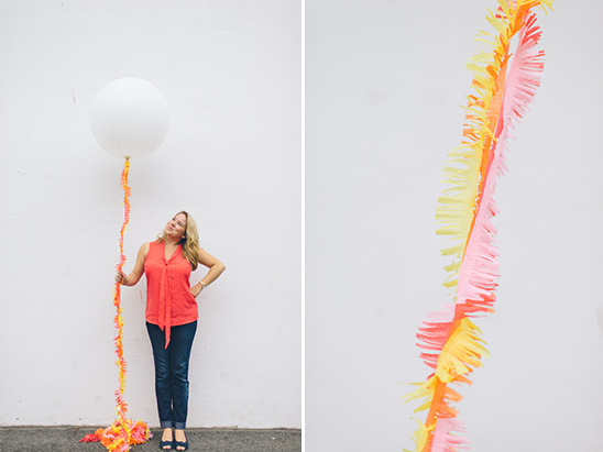 Woman holding large white balloon with colorful tail