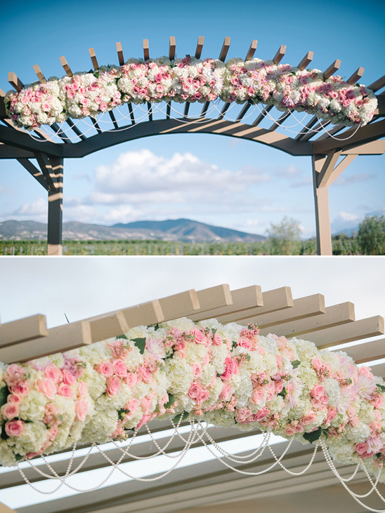 pink and white floral and pearl draped wedding arch