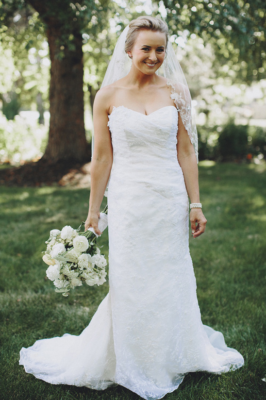Beautiful bride in lace wedding gown holding bouquet