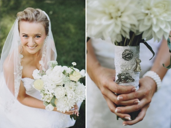 Bride holding white wedding bouquet with brooch details