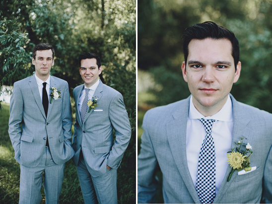 Wedding grooms in grey suits with boutonniere outdoors