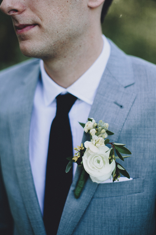 Groom in gray suit with white rose boutonniere